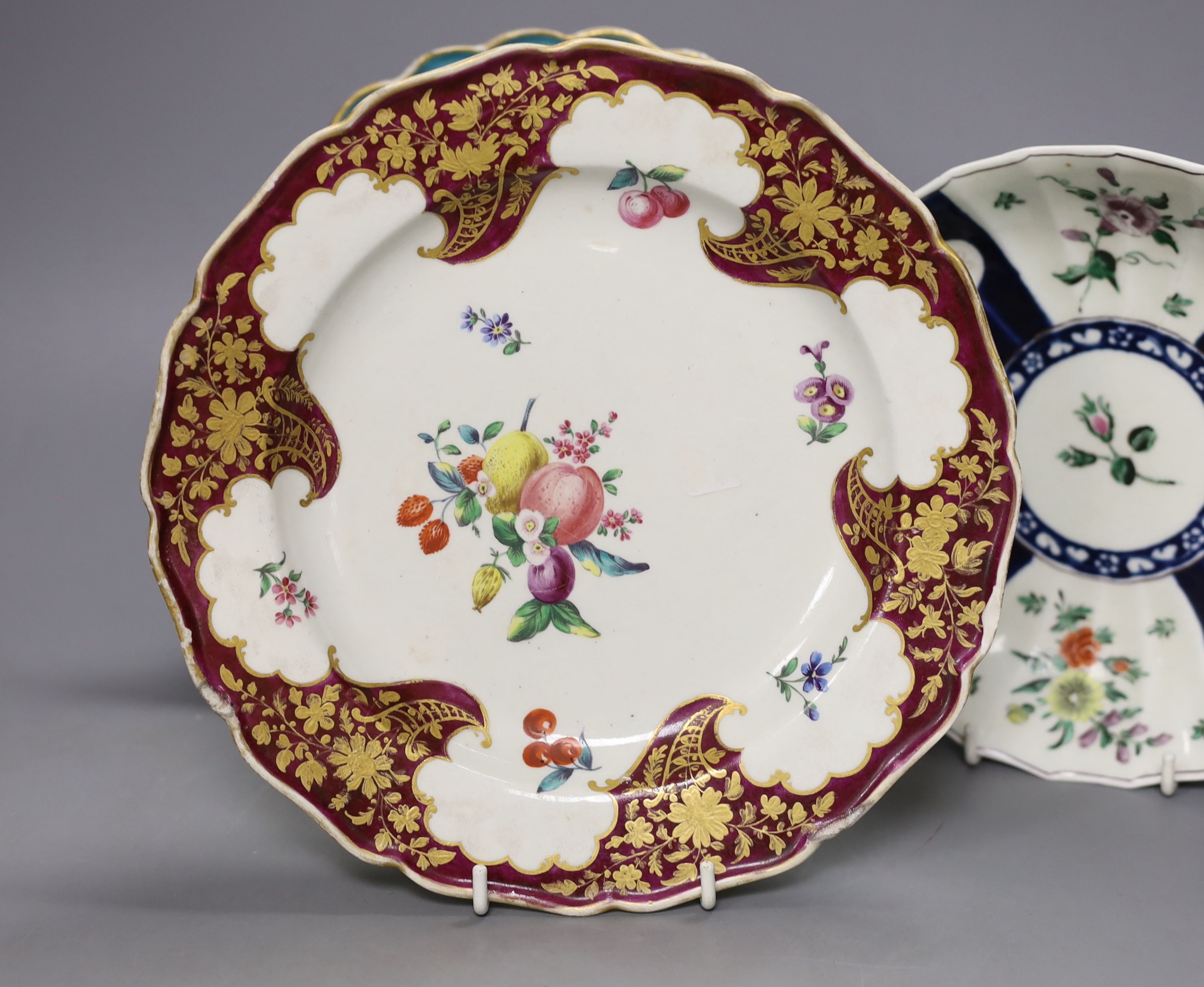 A Worcester plate with two turquoise borders, the centre painted with flowers, a saucer dish with fan shaped panels painted with flowers separated by blue panels and a claret ground plate, turquoise plate 21 cms diameter